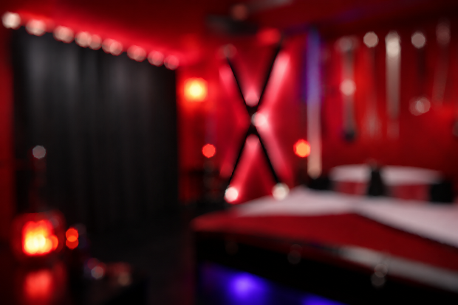 Red-lit private room with low furniture and soft black curtains